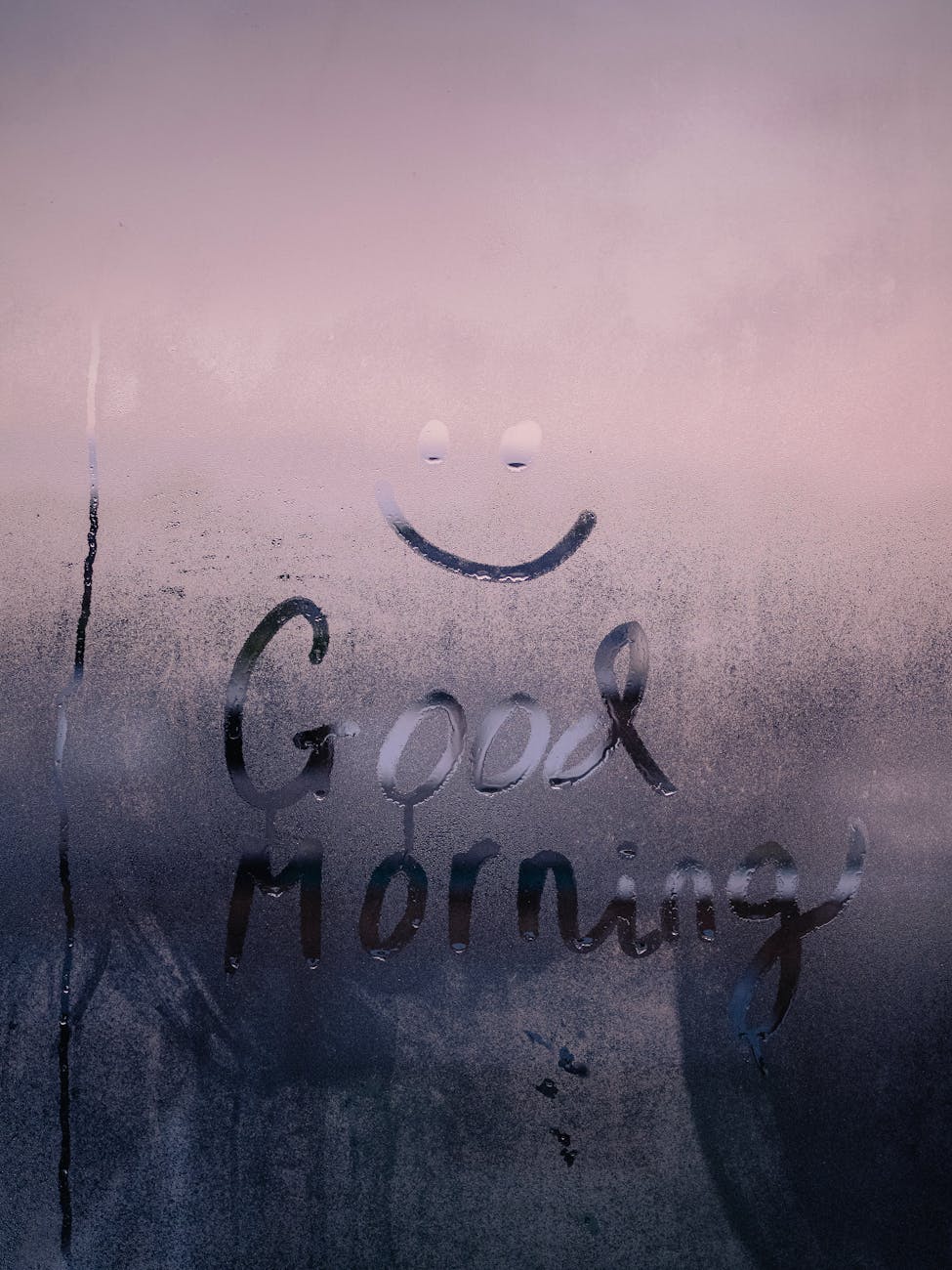 smiley face and good morning text painted on a foggy window